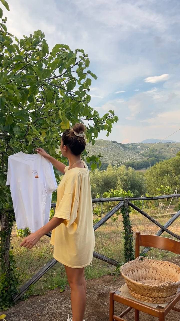 Michela Sharon appende una t-shirt Paneelatte tra gli alberi